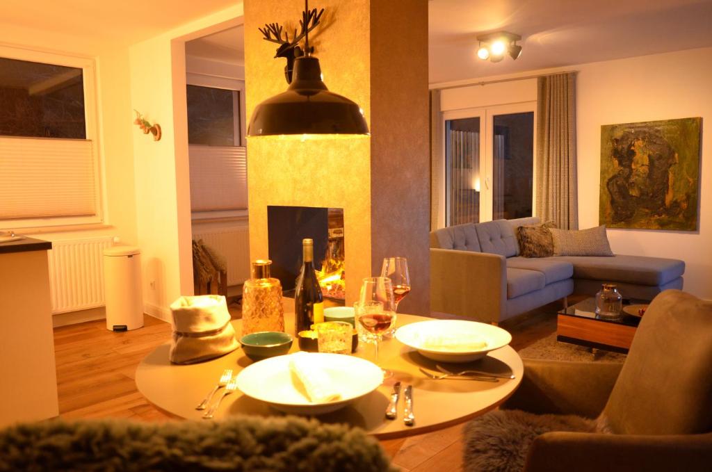 ein Wohnzimmer mit einem Tisch und einem Kamin in der Unterkunft Eifelsuite in Birresborn