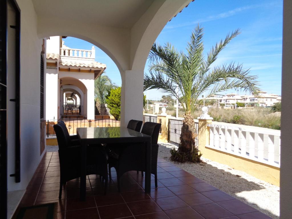 a patio with a table and chairs and a palm tree at Luxurious house in La Marina at El Pinet beach in La Marina