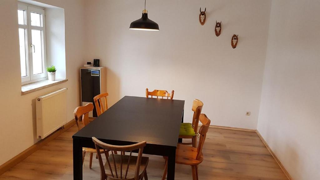 a dining room with a black table and chairs at Ferienwohnung Trogschneider Hof in Erbendorf