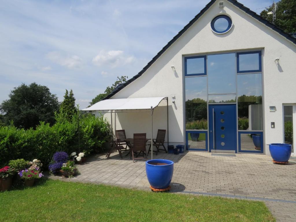 a cottage with a patio and a blue door at Reiners`Alm in Essen