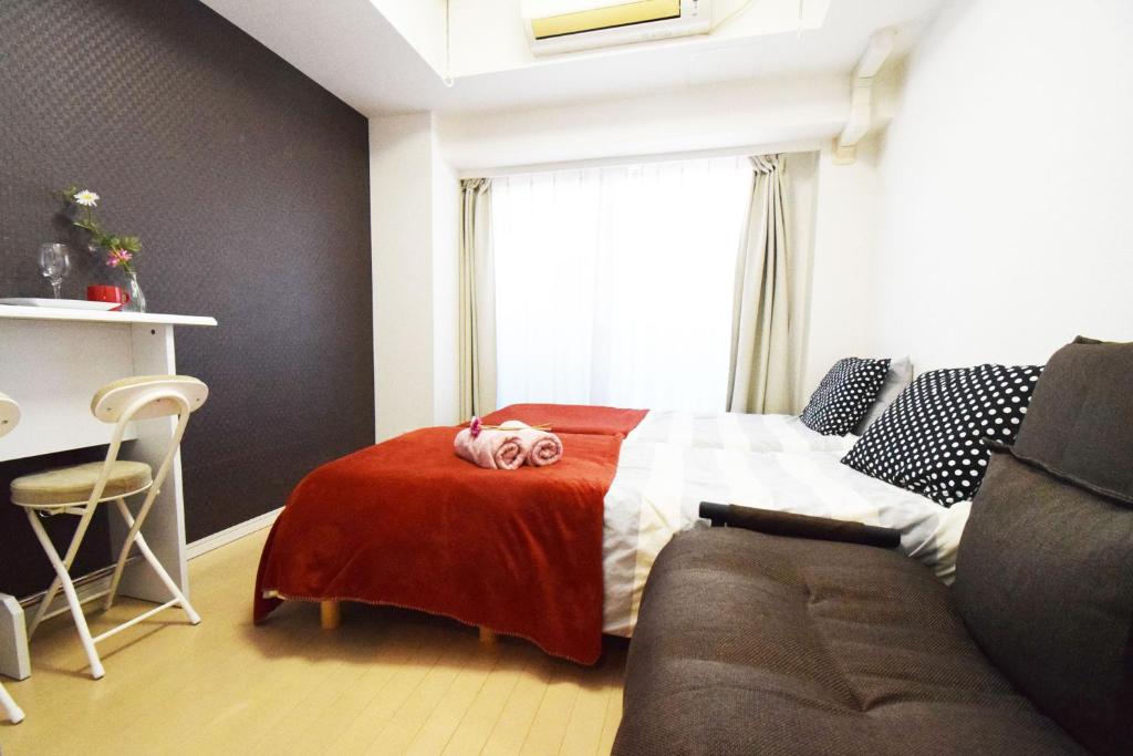 um quarto com uma cama e um sofá em Square Shibuya 407 em Tóquio