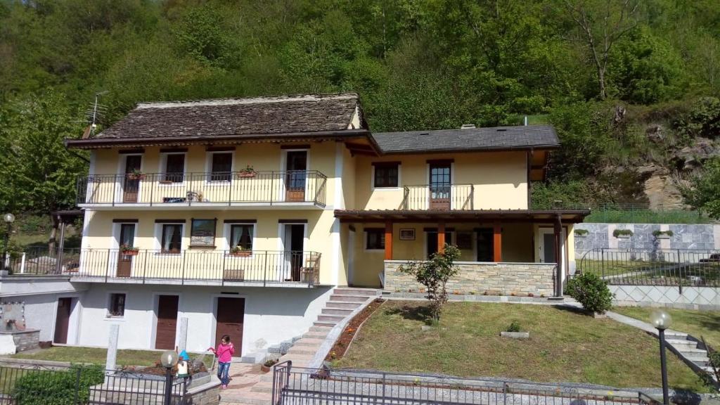 a woman walking in front of a house at Cat Marvei in Villadossola