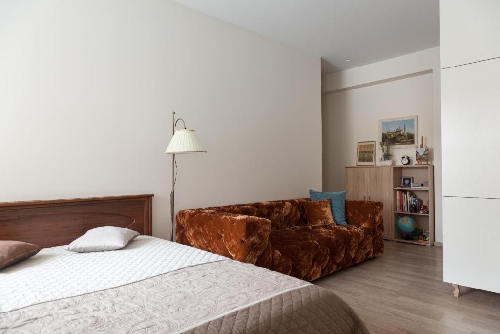 a bedroom with a bed and a couch at M.K. Apartments in Vilnius