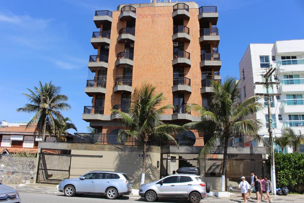 ein hohes Gebäude mit davor geparkt in der Unterkunft Apto confortável de 3 quartos-Cabo Frio in Cabo Frio