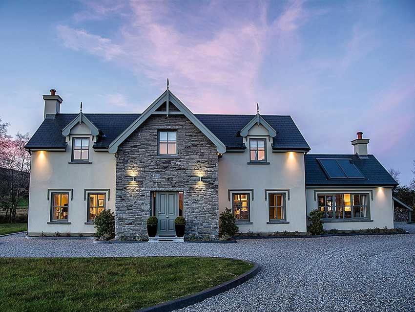 uma grande casa branca com luzes acesas em Beechwood 4, Kenmare - stay for more than 15 days em Killowen