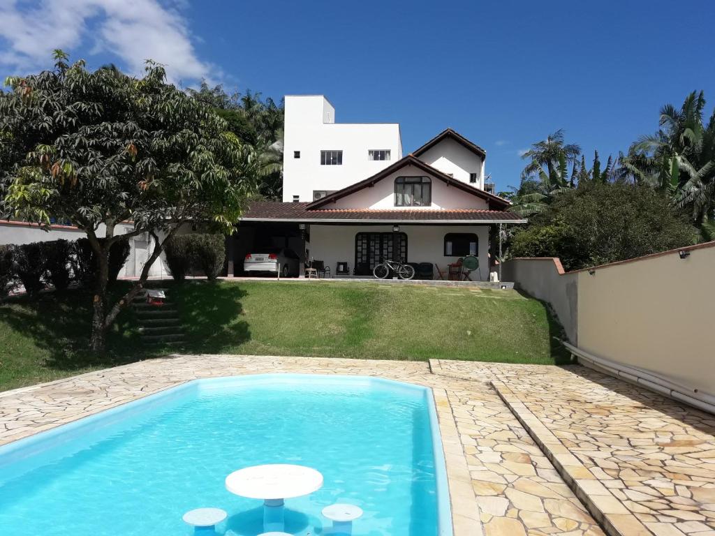 a swimming pool in front of a house at Loft Pinheiros in Blumenau