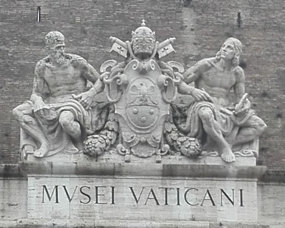 posąg dwóch mężczyzn siedzących na dachu budynku w obiekcie Da Adriana al vaticano w Rzymie