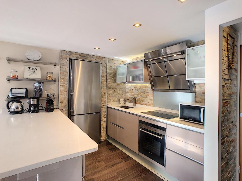 a kitchen with stainless steel appliances and wooden floors at Appartement Loft Cannes in Cannes
