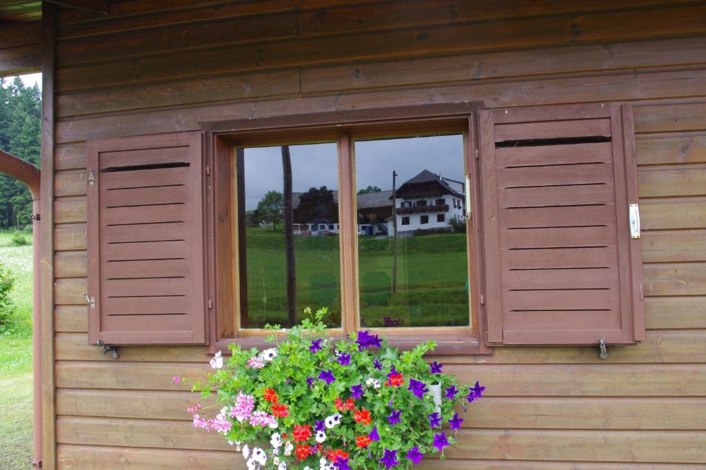 una ventana de una casa con una caja de flores en Ferienhaus Forellenwirt, en Grünbach