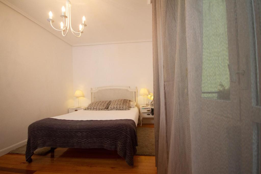 a bedroom with a bed and a chandelier at Los Respigos Ampuero in Ampuero