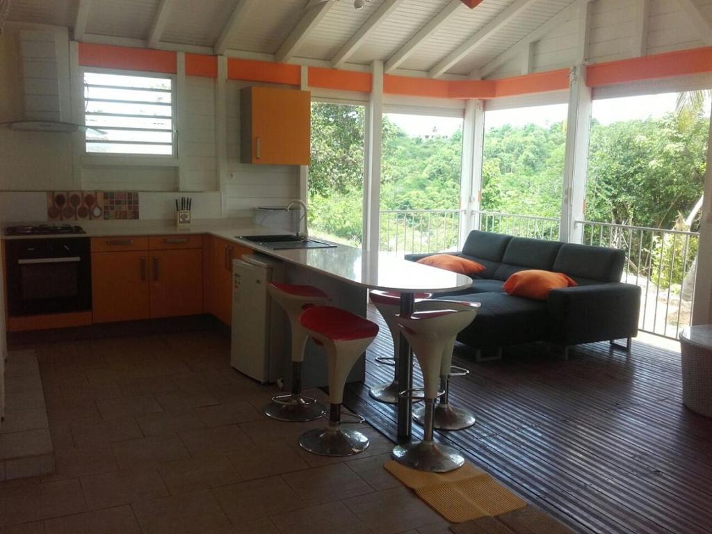 a kitchen and living room with a couch and a table at Lokation gwada in Sainte-Anne