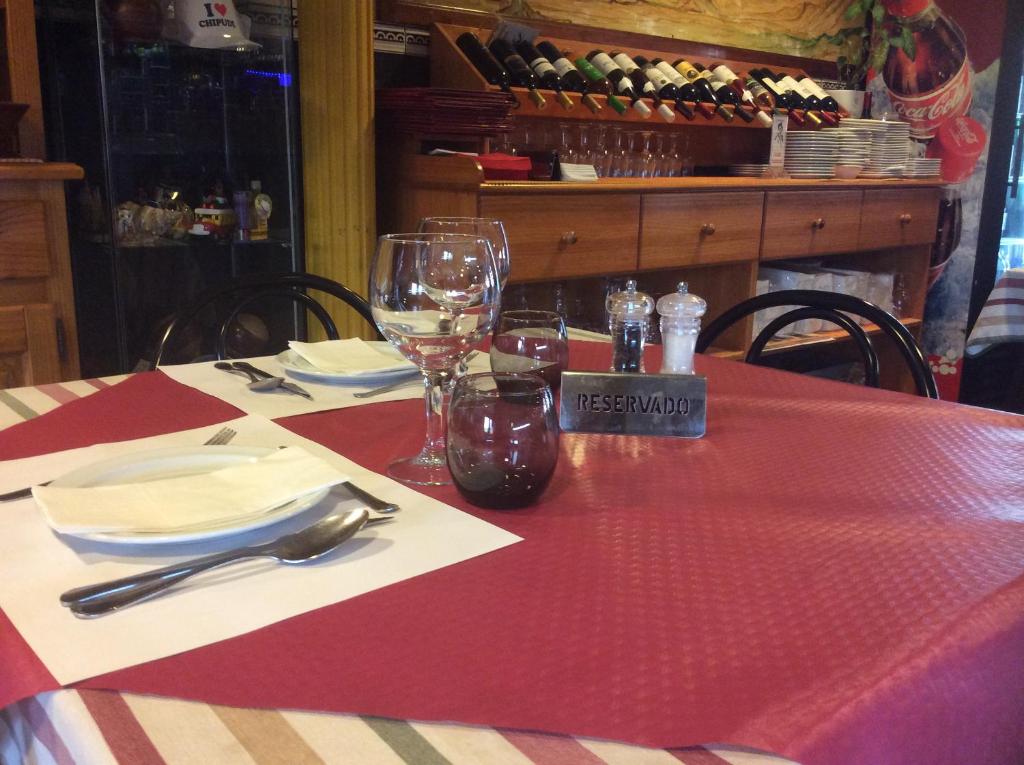 a table with a red and white table cloth and glasses at Hotel Sonia Chipude in El Cercado
