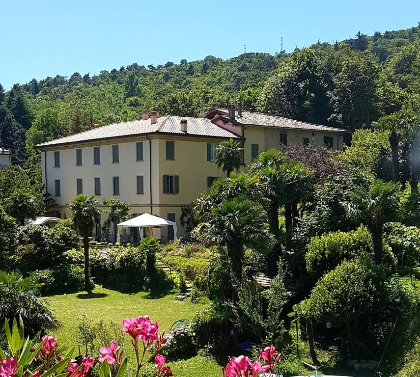 une maison avec un jardin planté de fleurs et d'arbres dans l'établissement Guest House Villa Corti, à Côme