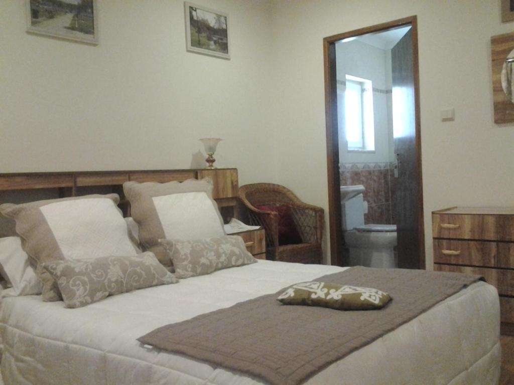 1 dormitorio con 1 cama grande y espejo en Hotel Azibo e Restaurante, en Podence
