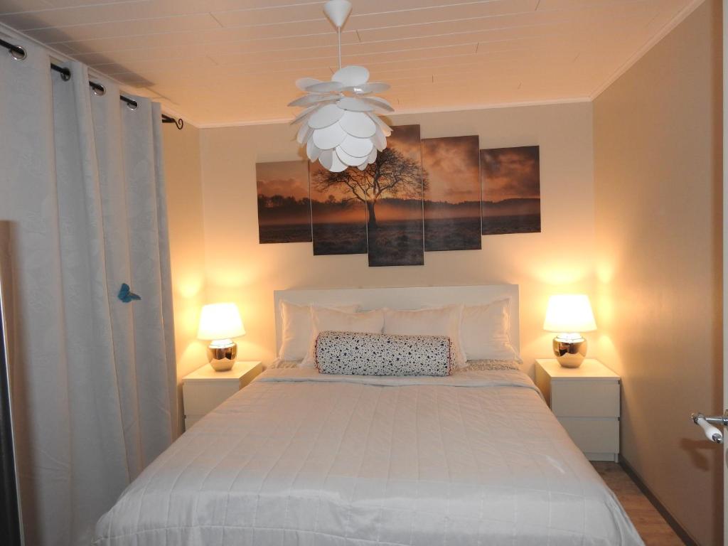 1 dormitorio con 1 cama blanca y 2 lámparas en Scandinavian Sleeping & Living en Turku