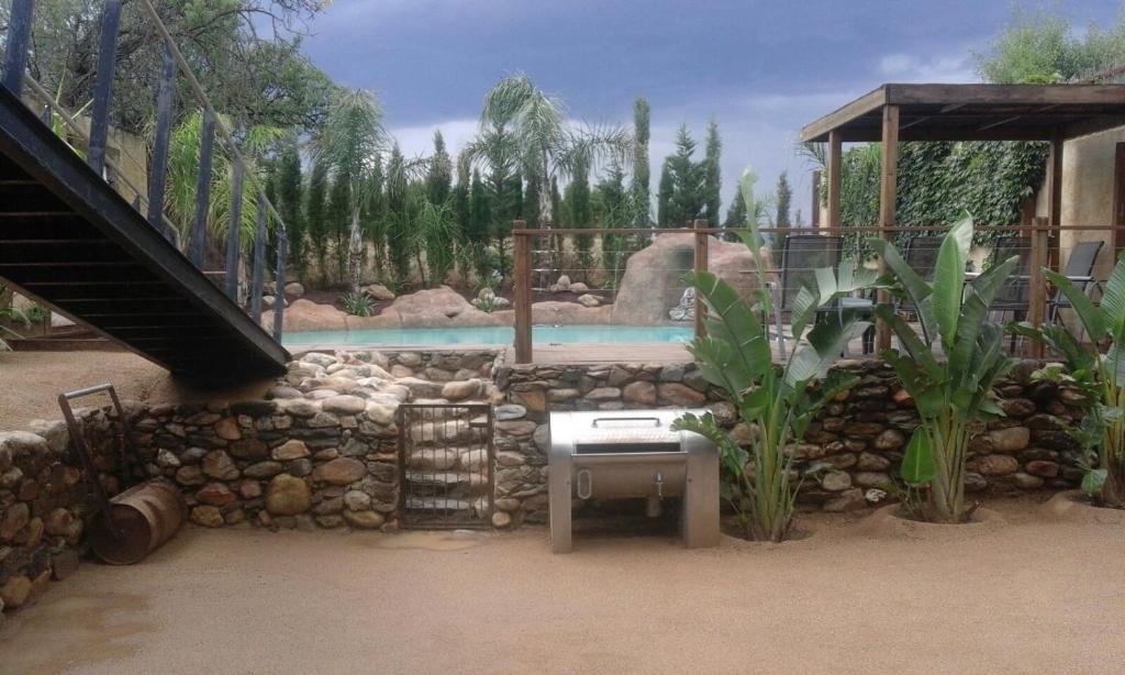 a backyard with a swimming pool and a stone wall at Can Jenot in Delfiá