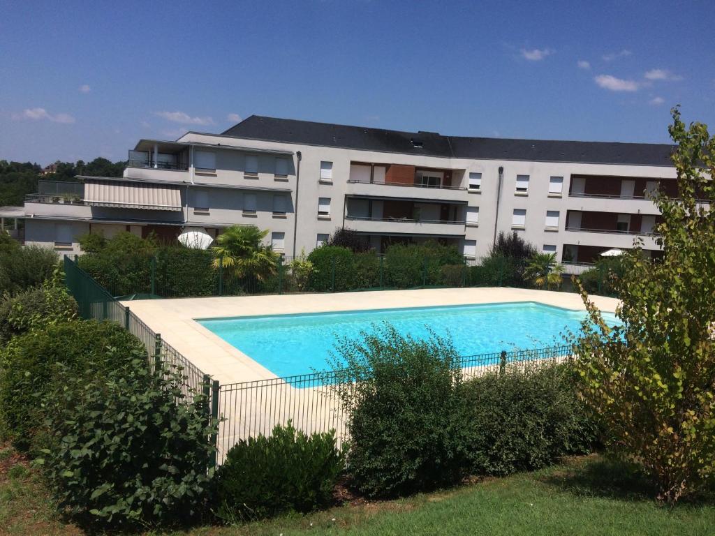 a swimming pool in front of a building at Résidence CAP HORIZON in Brive-la-Gaillarde