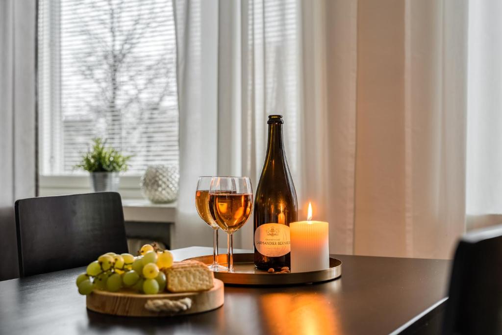 a bottle of wine and a candle on a table at Apartments Borg in Pori