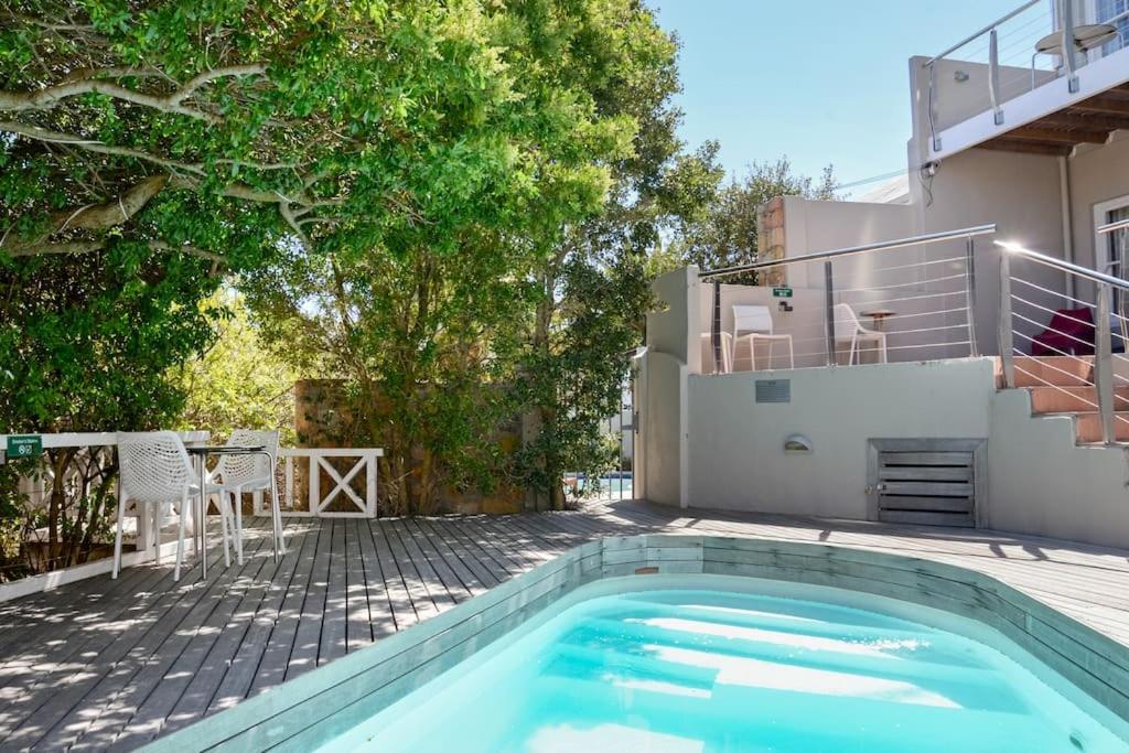 a swimming pool in front of a house at Camps Bay Nest in Cape Town