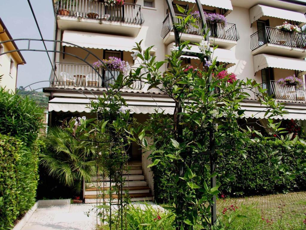 un edificio con flores y plantas delante de él en Hotel Marina, en Torri del Benaco
