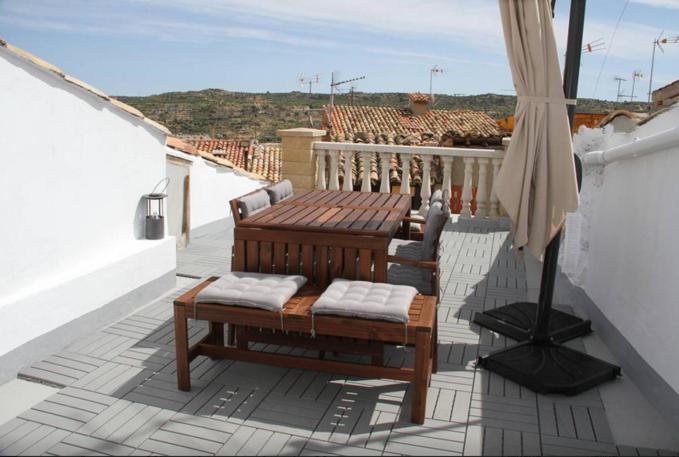 um pátio com uma mesa e cadeiras numa varanda em Circuito de Aragon. House up to 16 pax em Valdealgorfa