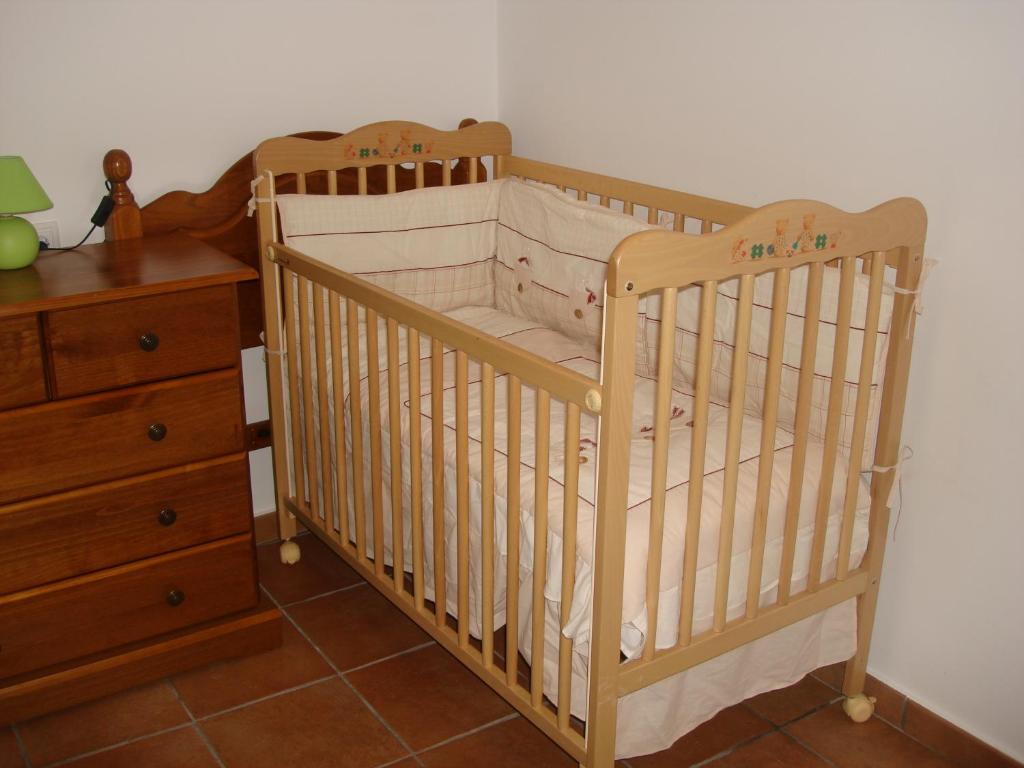 a wooden crib in a room with a dresser and a drawer at Casa Vallés in Adahuesca