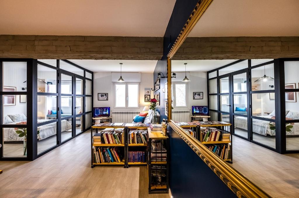 eine Bibliothek mit großen Fenstern und Bücherregalen in der Unterkunft Logroño Centro, Una Casa con Vistas in Logroño