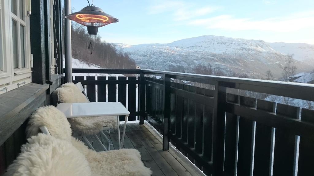 a balcony with a bench and a view of mountains at Røldal in Røldal