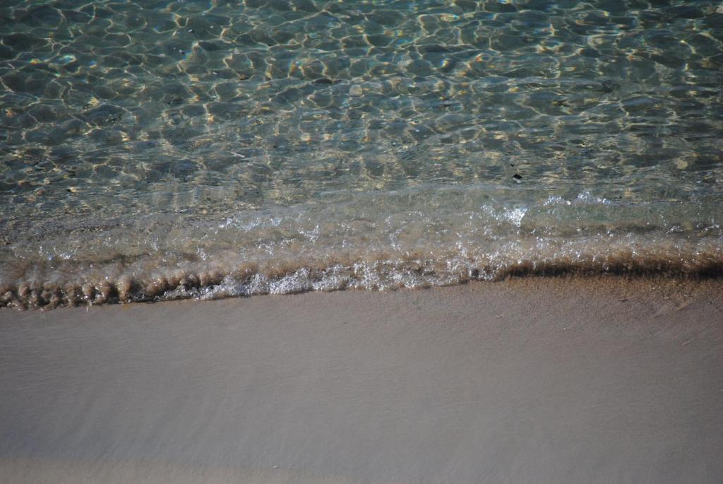 a close up of the water on the beach at Summer Beach Rooms in Fontane Bianche
