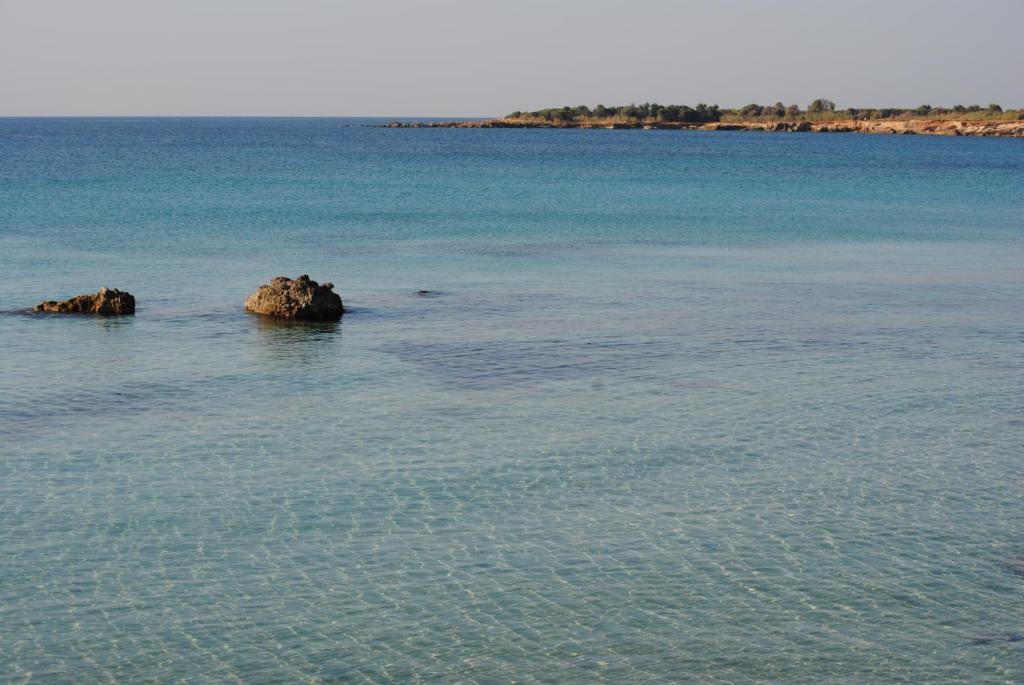 two rocks in the middle of a large body of water at Summer Beach Rooms in Fontane Bianche