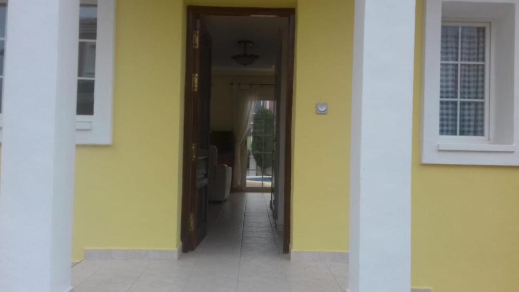 Baños y Mendigo的住宿－Nita Villa Altaona Golf Mosa Turquesa，黄色墙屋的走廊