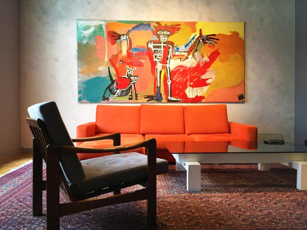 a living room with an orange couch and a chair at Design Atelier in Sarajevo