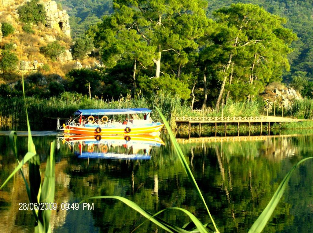a yellow boat on the water near a bridge at Dalyan Terrace Hotel in Dalyan