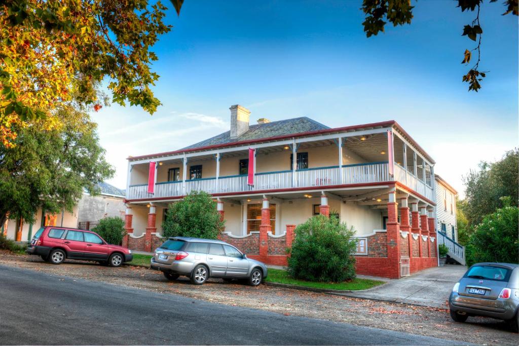 a red brick house with cars parked in front of it at Athelstane House in Queenscliff