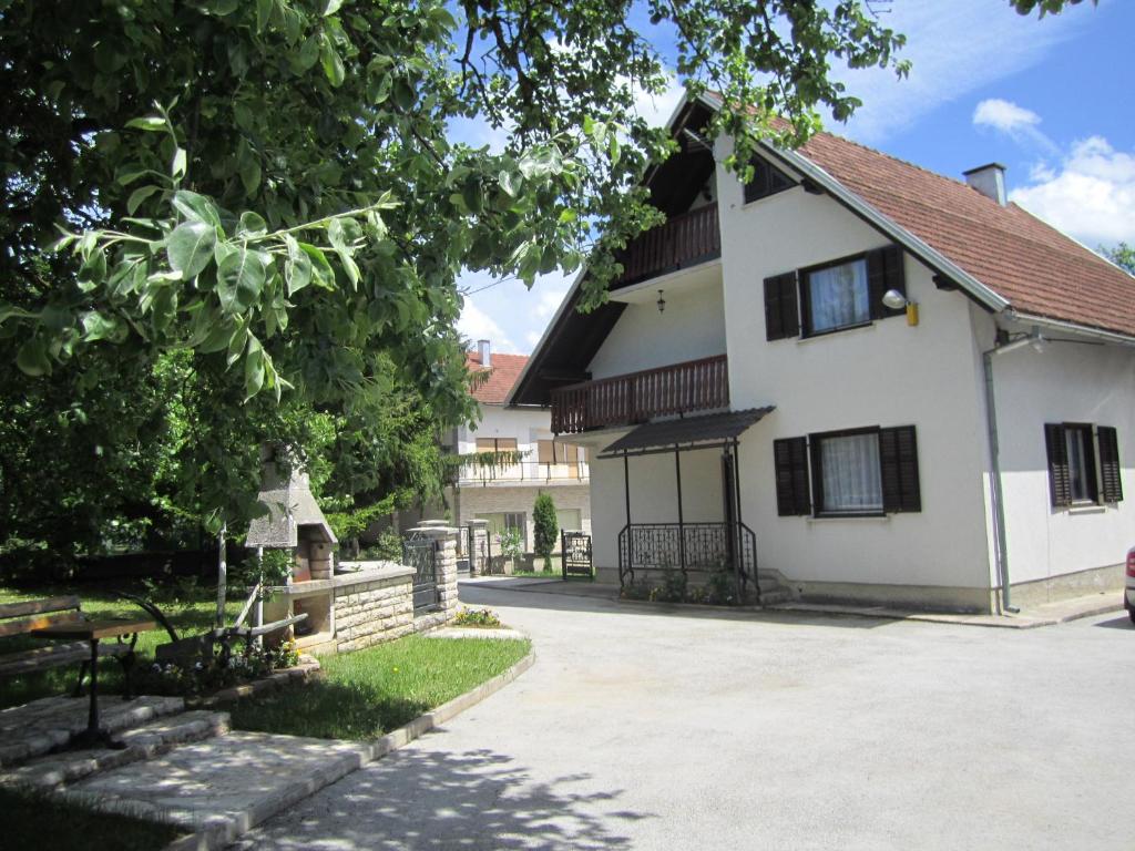 una casa blanca con una entrada delante de ella en Guest House Sveti Marko Gacka, en Otočac