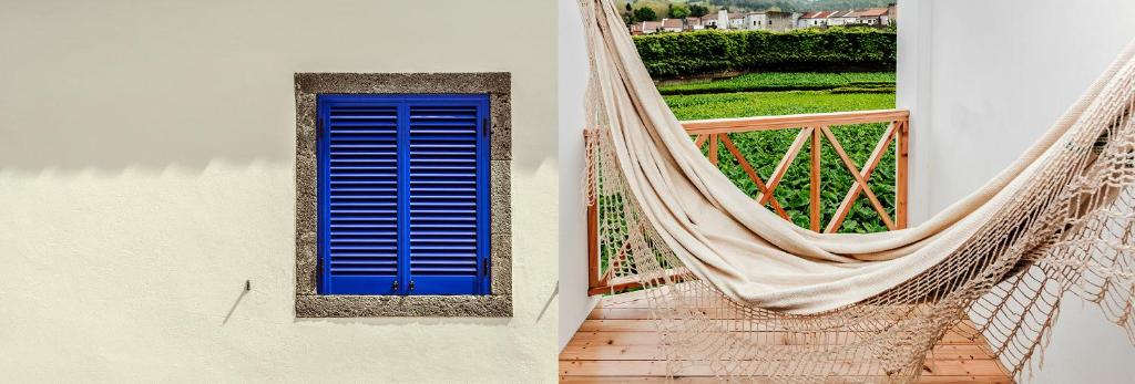 a hammock and a blue door and a window at Casa Azul da Beija in Furnas