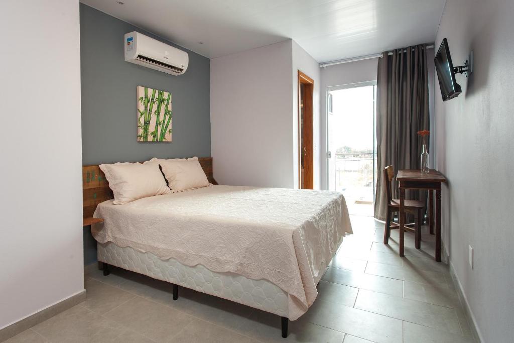 1 dormitorio con 1 cama en una habitación con ventana en Pousada Moquirido, en Florianópolis