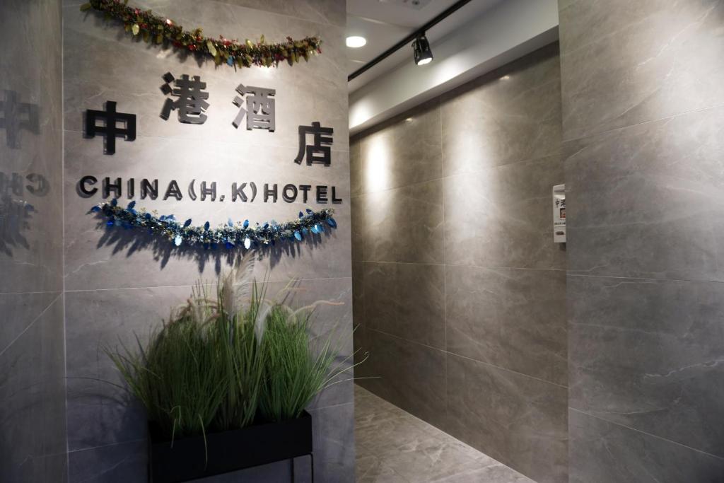 a lobby with a wall with a chinese sign and a plant at China HK Motel in Hong Kong