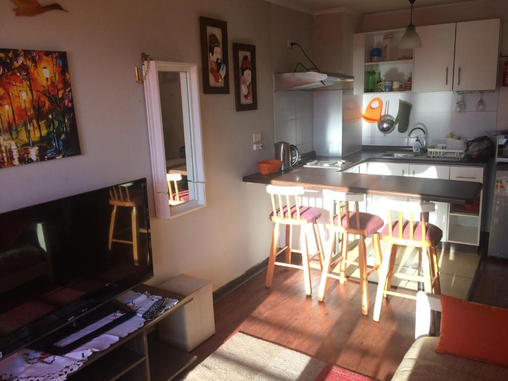 una cucina e un soggiorno con bancone e sgabelli di Apartamentos Armando a Santiago