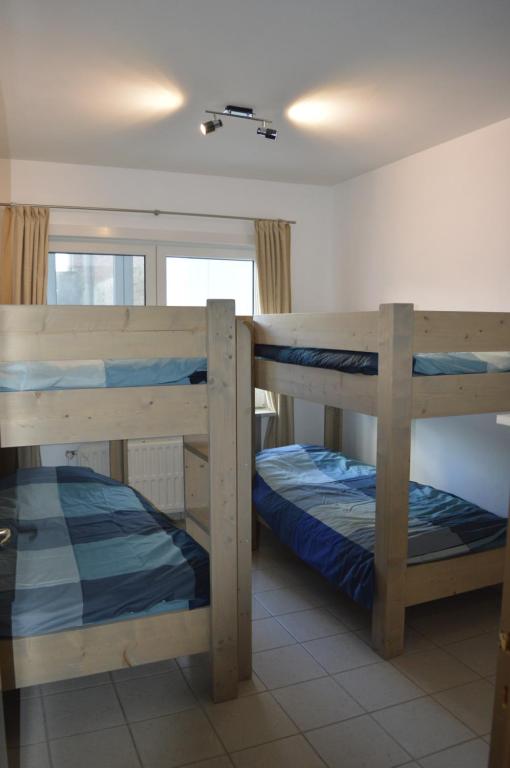 2 Etagenbetten in einem Zimmer mit Fenster in der Unterkunft Residentie Paola in Ostende