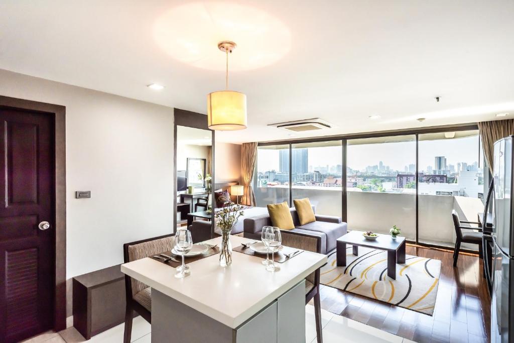 een woonkamer met een bank en een tafel bij Royal Suite Hotel Bangkok in Bangkok