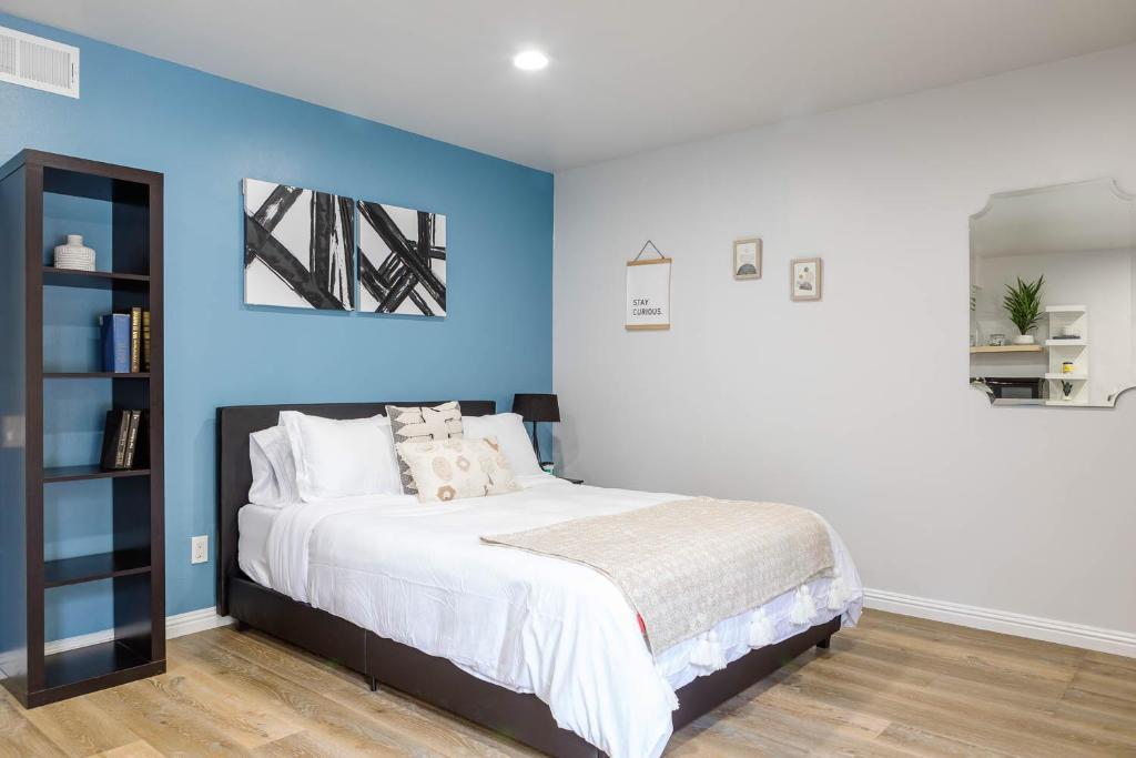 a bedroom with a bed with a blue wall at Spacious Guest Studio with Private Entry in Los Angeles