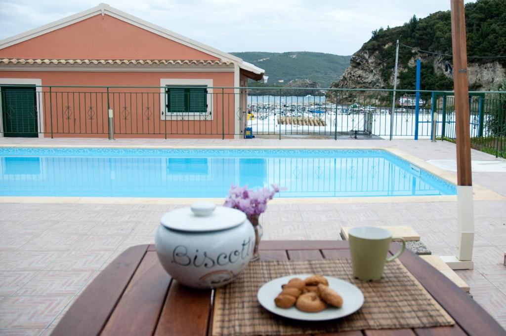 een tafel met een theepot en een bord donuts bij Akis Apartments in Paleokastritsa