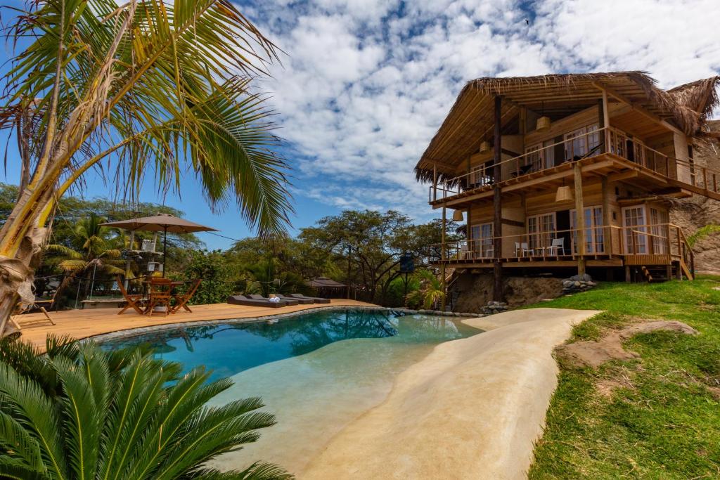 a house with a swimming pool in front of a house at Amai Luna in Máncora