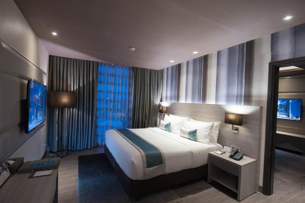 セブシティにあるbai Hotel Cebuのベッドとテレビがあるホテルの部屋