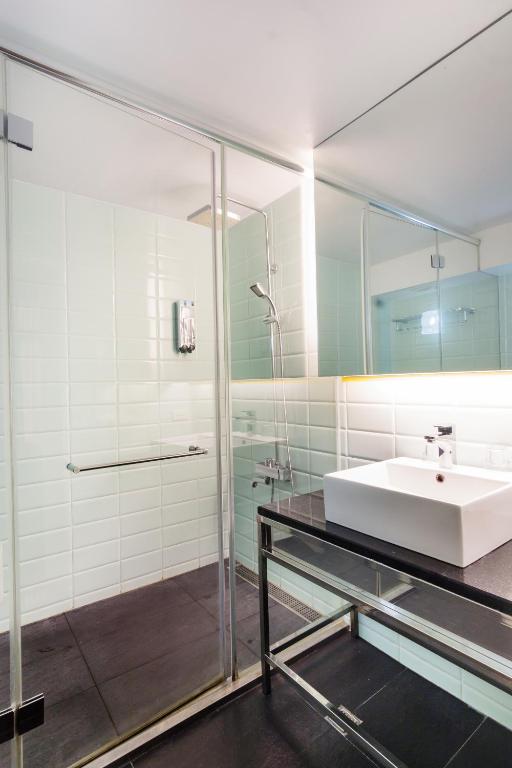 a bathroom with a sink and a glass shower at Taitung Spring Homestay B&amp;B in Taitung City