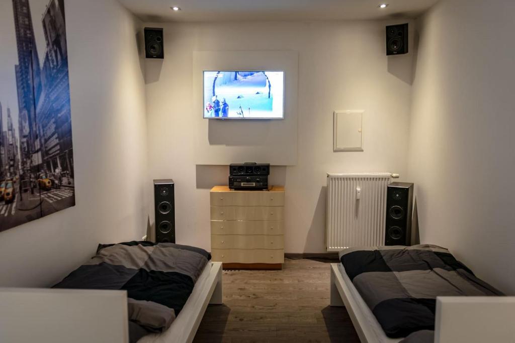 um quarto com duas camas e uma televisão na parede em Ruhige Ferienwohnung mitten im Zentrum em Plauen
