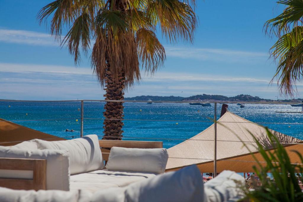 a living room with a view of the ocean and palm trees at Vic's Land Holidays in Grimaud