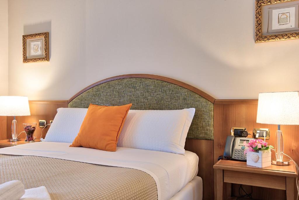 a bedroom with a bed and two tables with lamps at Albergo Villa Priula in Sorisole
