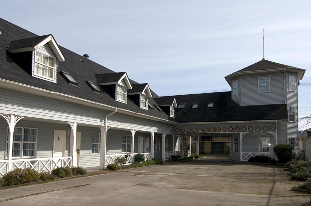 a large house with white trim and a black roof at Apart Hotel Casablanca in Valdivia